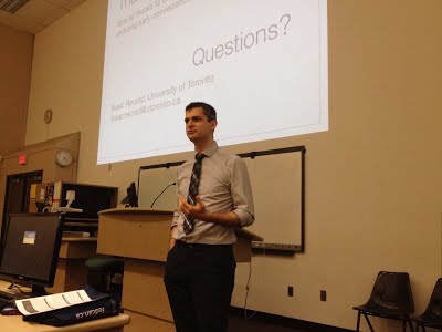 Any questions? Photo of Isaac Record during a Q/A session of a conference presentation.
