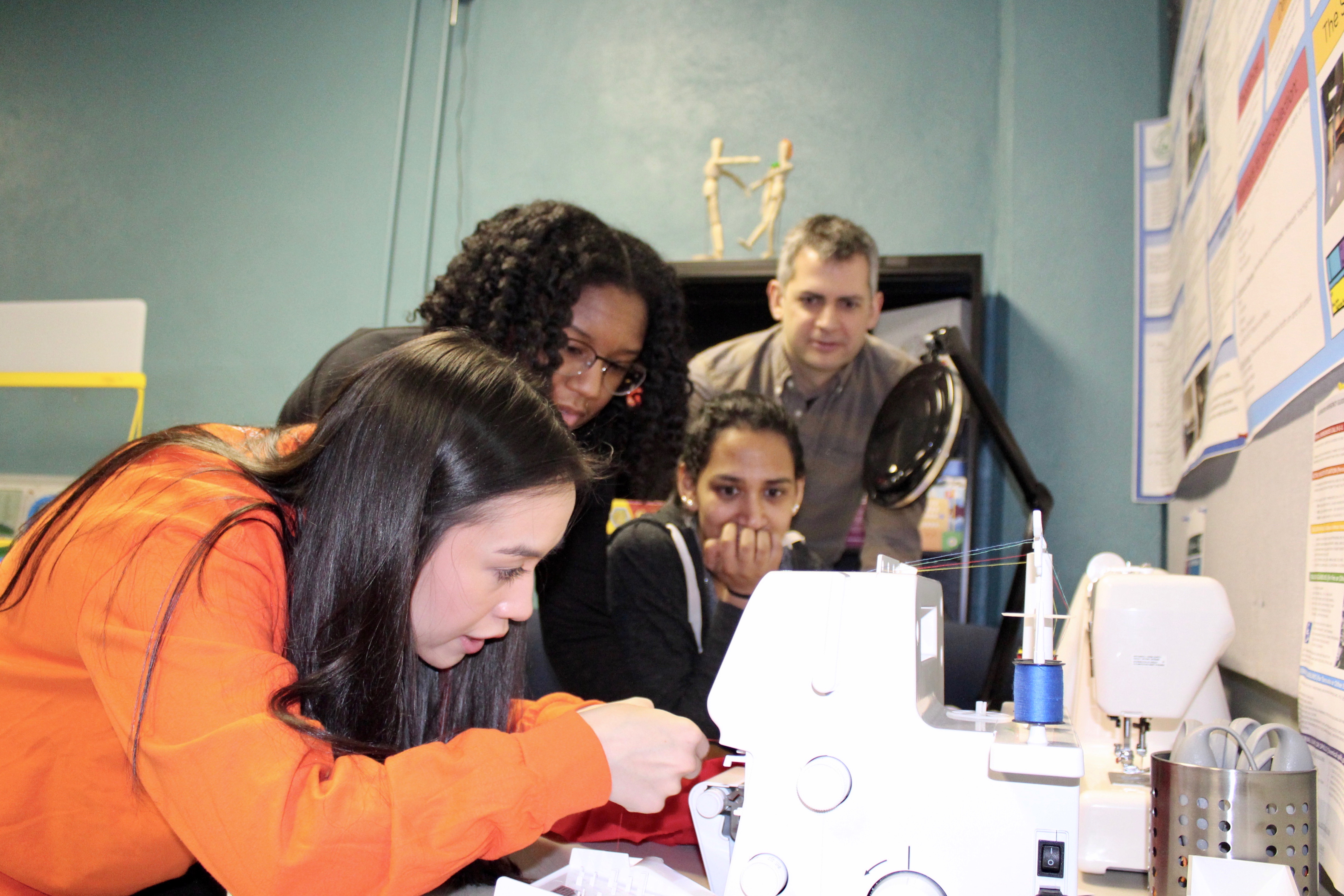students demonstrating how to use the sewing machine and serger. Photo credit: Piper Cook, LBC