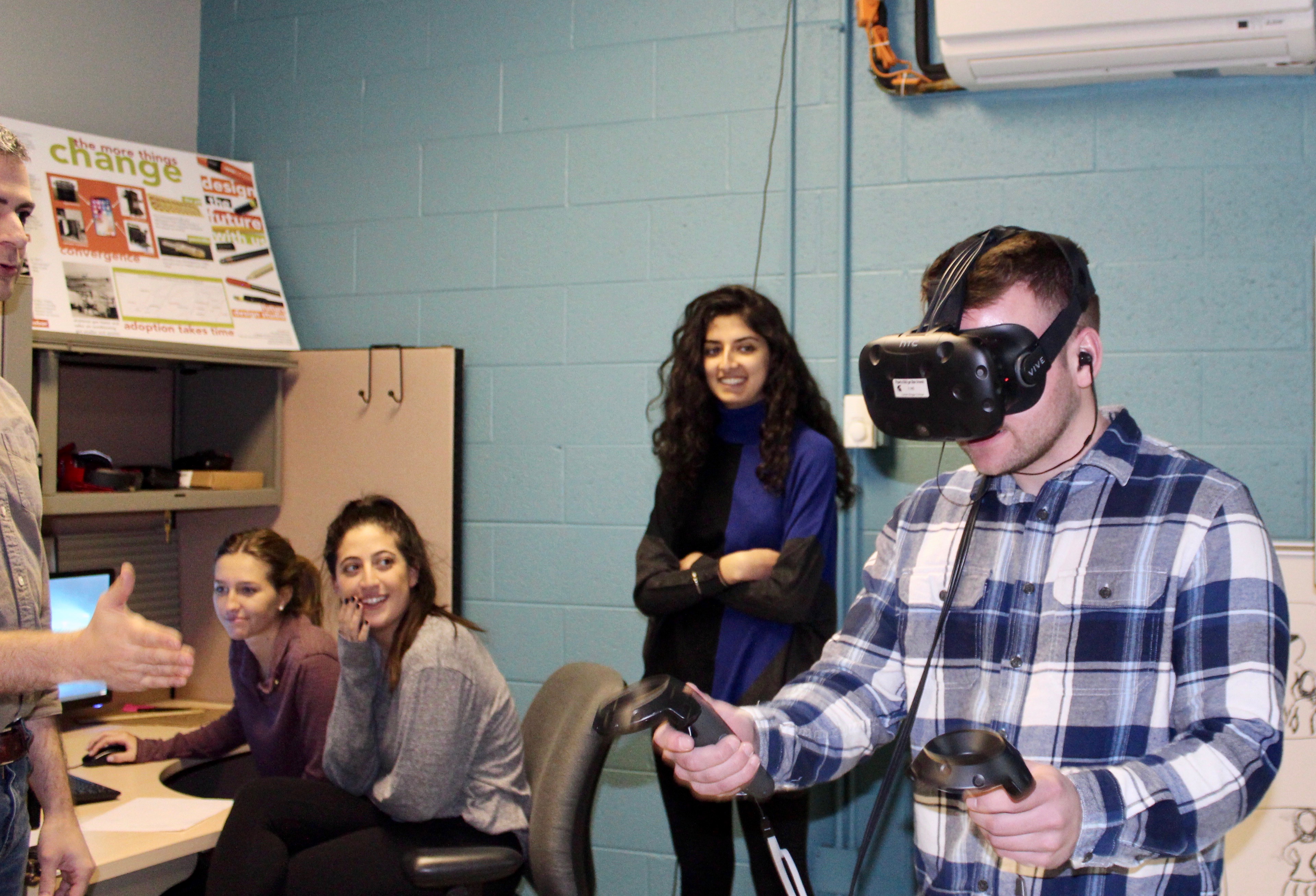 a student explores a virtual realm as other students look on. Photo credit: Piper Cook, LBC